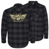 FloydFest Flannel Shirt in charcoal and black buffalo plaid pattern, featuring a gold eagle logo design on back with 'Music Magic Mountains' text. Classic button-front style with chest pockets and roll-up sleeves.