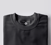 Team Tammy Crew: Ultra Cozy crewneck sweatshirt in black, featuring a folded neckline with Chaos Goblin brand tag and size M label visible, displayed on a light gray background showcasing premium quality fleece material and clean stitching details.