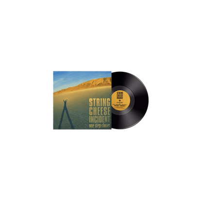 One Step Closer Vinyl by String Cheese Incident featuring album artwork with desert landscape, golden mountain backdrop against blue sky, and elongated shadow cast on sandy terrain, with classic black vinyl record and yellow label visible