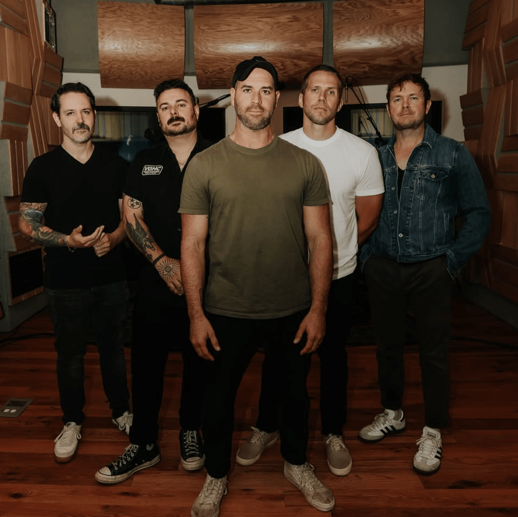 The five members of Conditions standing in the studio