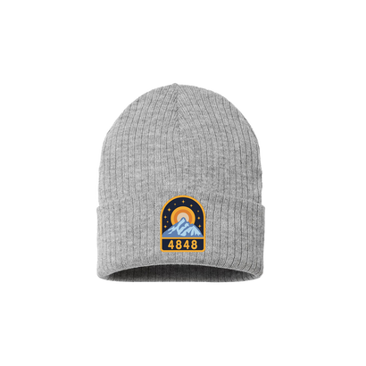 Light Gray knit beanie with a 4848 festival mountain patch featuring black, gold and shades of blue. 