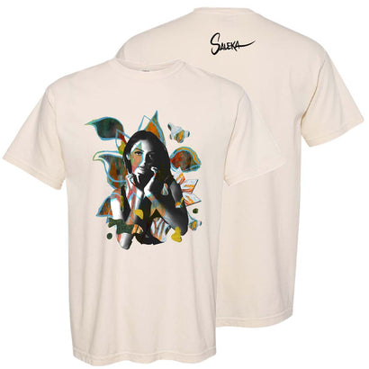 Saleka Painting Tee featuring an artistic design on cream-colored cotton t-shirt with abstract geometric shapes and colorful elements in teal, orange, and black. Signature Saleka text on back. Classic fit with ribbed collar and straight hem.