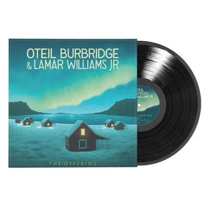 Vinyl record partially pulled from sleeve featuring houses under northern lights with artist names and album title on cover