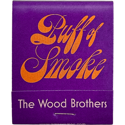 Purple matchbook with orange swirling text Puff of Smoke and the words The Wood Brothers in white below