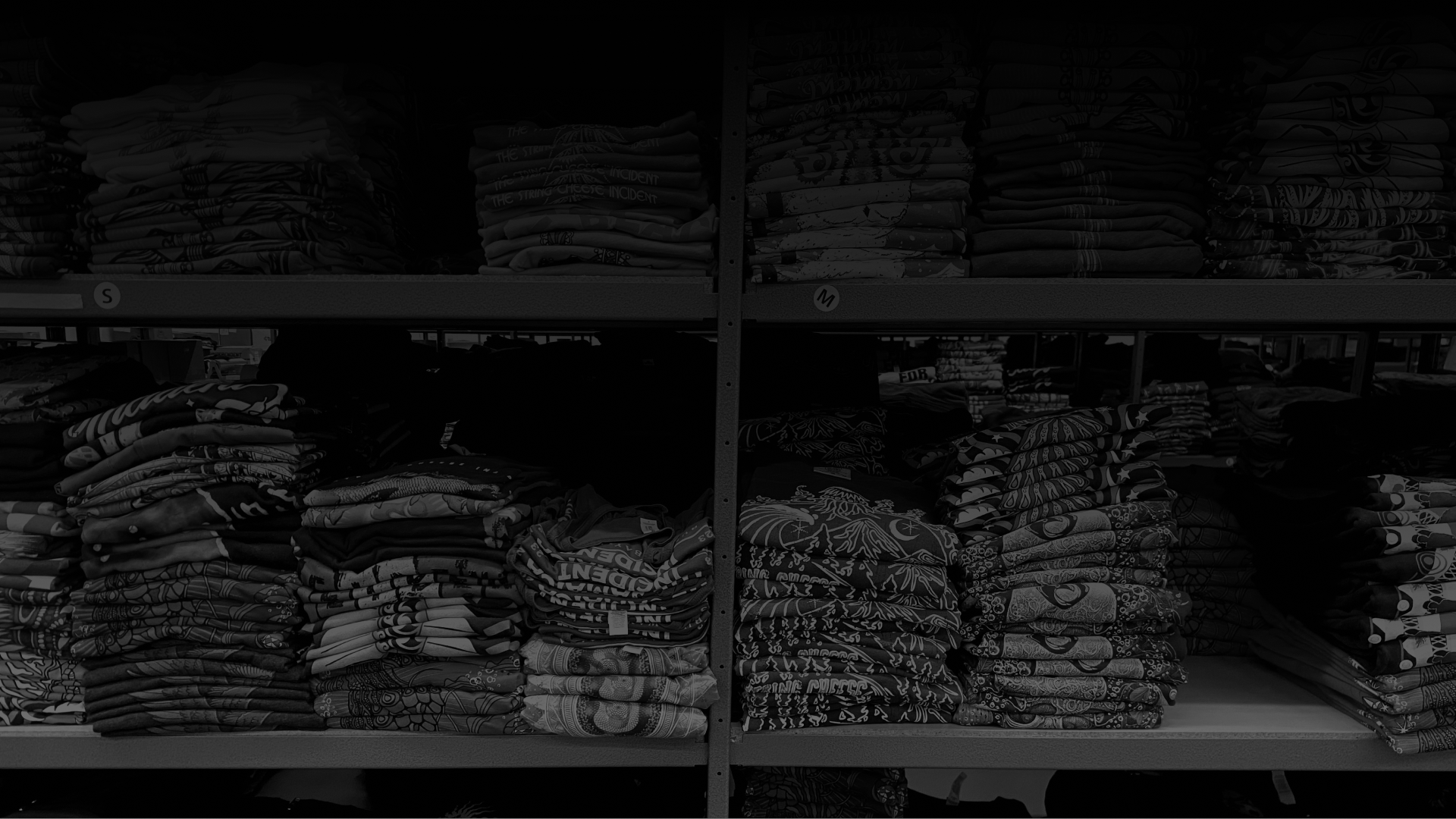 Shelves of folded T-Shirts in the Press Press Merch Warehouse