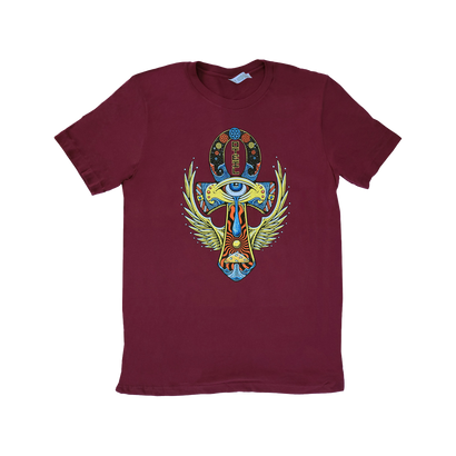 Maroon t-shirt featuring colorful Egyptian-inspired design with Ankh symbol, winged eye motif, and decorative elements in vibrant hues of blue, green, and yellow against the dark red background