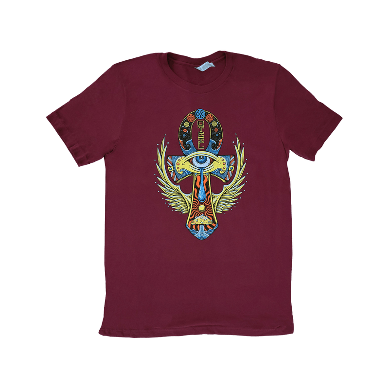 Maroon t-shirt featuring colorful Egyptian-inspired design with Ankh symbol, winged eye motif, and decorative elements in vibrant hues of blue, green, and yellow against the dark red background