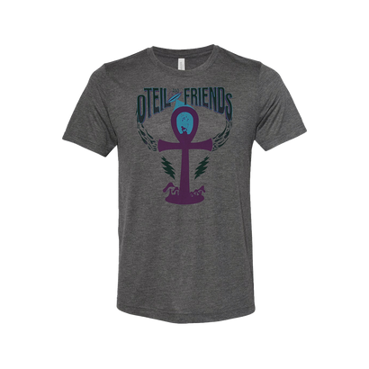 Gray unisex t-shirt featuring Oteil & Friends logo with a purple ankh symbol at the center, surrounded by stylized wings and lightning bolts in teal. The design combines Egyptian symbolism with a modern rock band aesthetic.