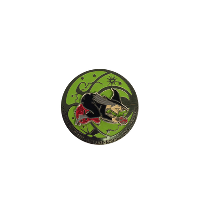 2014 Live Oak FL Hulaween Pin featuring a circular design with a witch on a broomstick silhouetted against a bright green background, with black border and celestial details, part of The String Cheese Incident's limited edition merchandise collection