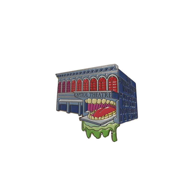 2014 Port Chester Capitol Theater Pin featuring a whimsical design of the historic theater building with a playful monster mouth entrance, rendered in vibrant red, blue and green colors. Limited edition collectible enamel pin from The String Cheese Incident concert series.