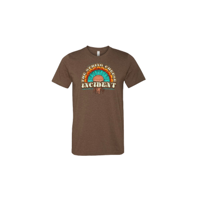 2021 Mission Ballroom Thanksgiving Tee featuring a brown crew neck shirt with a vibrant turquoise and orange semicircular design incorporating jellyfish and turkey feather elements, with The String Cheese Incident band name displayed in retro-style typography