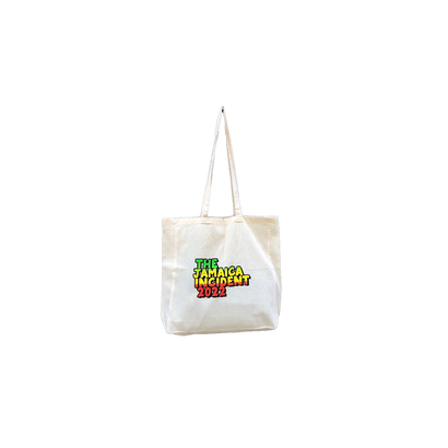 Natural cotton tote bag featuring Jamaica Incident 2022 logo in vibrant red, yellow, and green Jamaican-inspired colors on white background, with long shoulder straps and spacious gusset bottom design