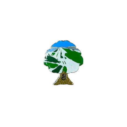 Tree-shaped enamel pin featuring Beech Mountain ski slopes with green and white trails, blue sky, and brown trunk, symbolizing the String Cheese Incidents 2024 Beech Mountain Concert