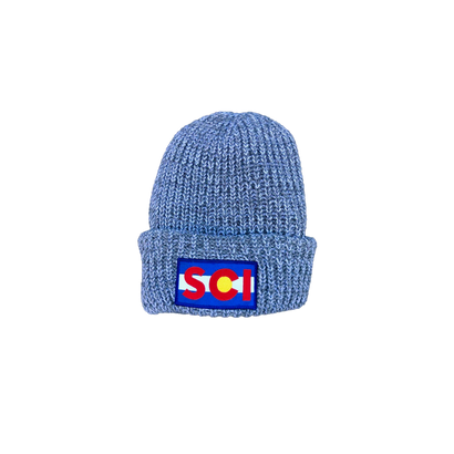 Flag Beanie in heather grey knit featuring a Colorado-inspired flag patch. Chunky ribbed texture winter hat with folded cuff and distinctive red, yellow, and blue logo emblem against speckled wool-blend material.