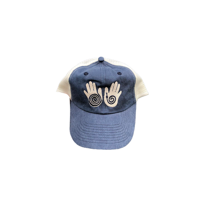 Little Hands Hat in navy blue with stone mesh back, featuring embroidered palm designs with spiral patterns in light beige on the front panel. Classic trucker-style cap with curved brim and adjustable snapback.