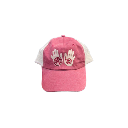 Little Hands Hat in brick pink with white mesh back, featuring embroidered hand designs with spiral patterns on the front panel. Classic trucker cap style with curved brim and adjustable snapback closure.