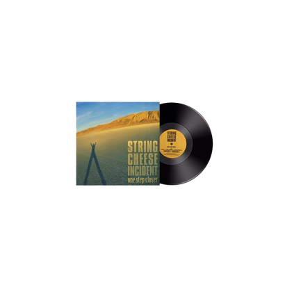 One Step Closer Vinyl by String Cheese Incident featuring album artwork with desert landscape, golden mountain backdrop against blue sky, and elongated shadow cast on sandy terrain, with classic black vinyl record and yellow label visible