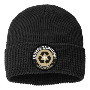 Black waffle knit beanie with cuffed design featuring a circular recycling emblem patch. The textured winter hat displays a stretchy waffle pattern throughout, with a fold-up brim for added warmth and style.