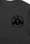 Close-up of a black crewneck sweatshirt featuring a circular logo design with the text
